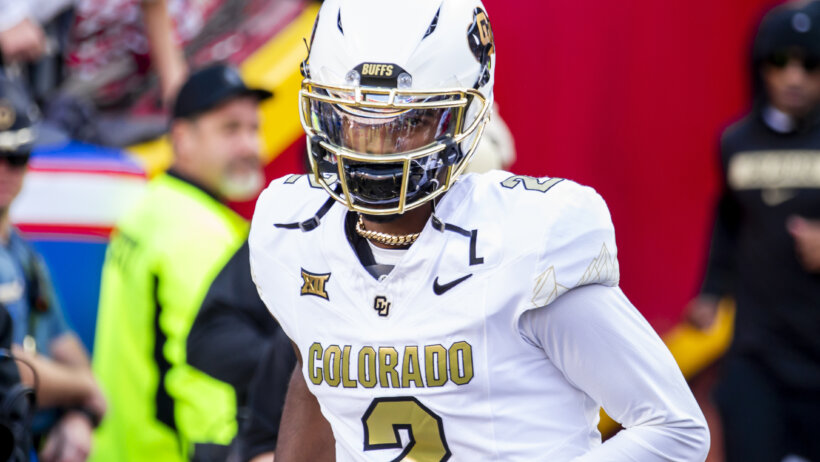 Shedeur Sanders runs onto the field.