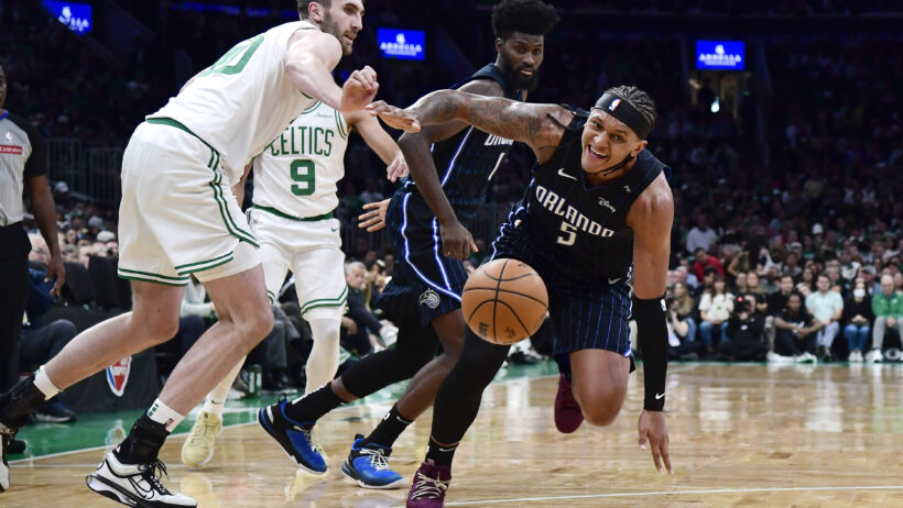 Boston Celtics center Luke Kornet and Orlando Magic forward Paolo Banchero go after a loose ball