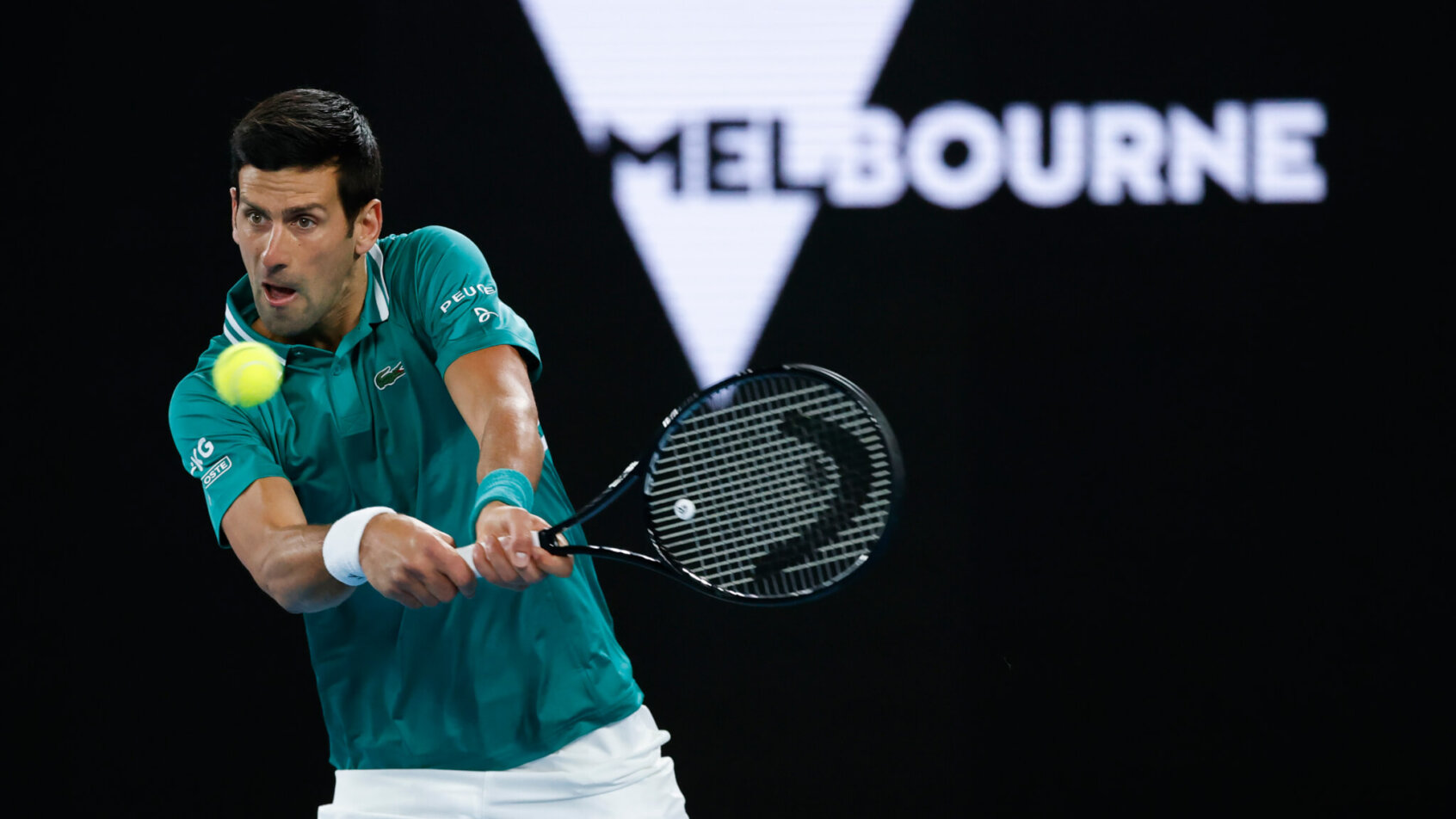 Novak Djokovic hitting a backhand shot in return during a Australian Open match.
