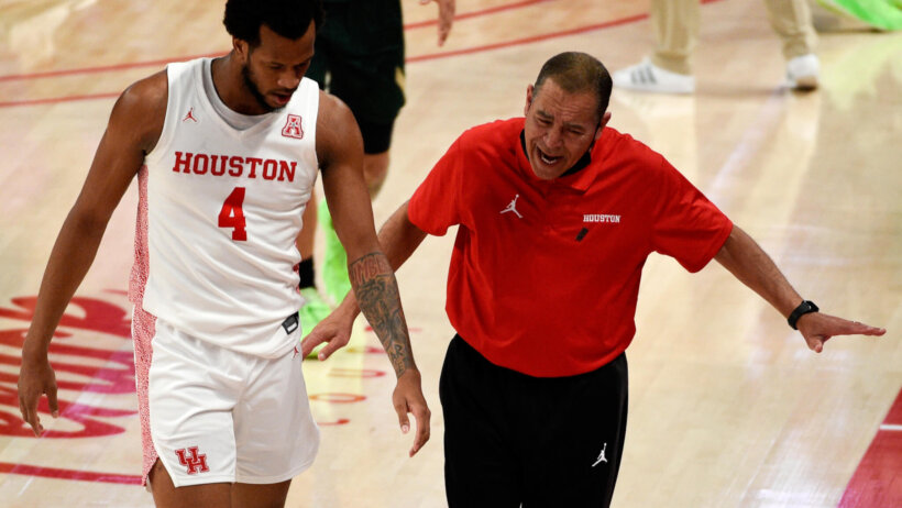 Houston's head coach Kelvin Sampson walking and talking with forward Justin Gorham as they come off the court.