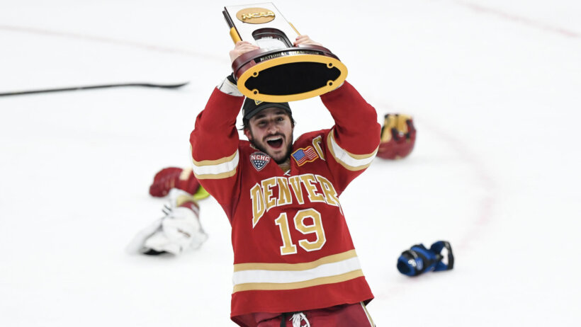 Denver Pioneers forward Cole Guttman celebrates the Frozen Four trophy