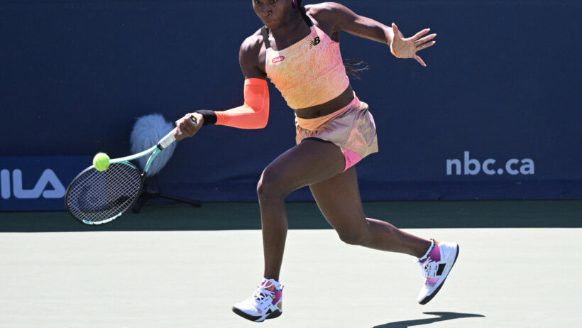 Coco Gauff hitting a return shot during a tennis match at the National Bank Open.