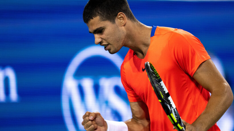 Carlos Alcaraz celebrating with a fist pump after defeating an opponent.