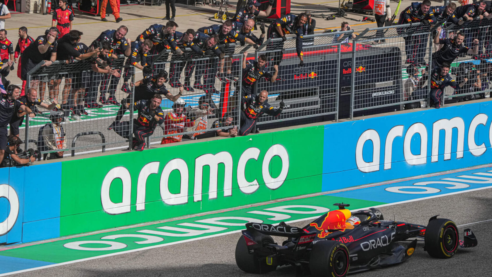 Team Oracle Red Bull Racing hangs off the pit wall as Max Verstappen wins a race