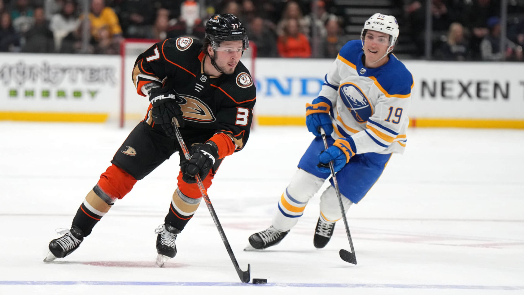 Anaheim Ducks center Mason McTavish skates with the puck pursued by Buffalo Sabres center Peyton Krebs
