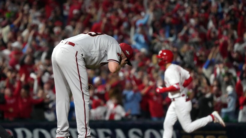 Arizona Diamondbacks pitcher Merrill Kelly holds his head in his hands after a Trea Turner home run