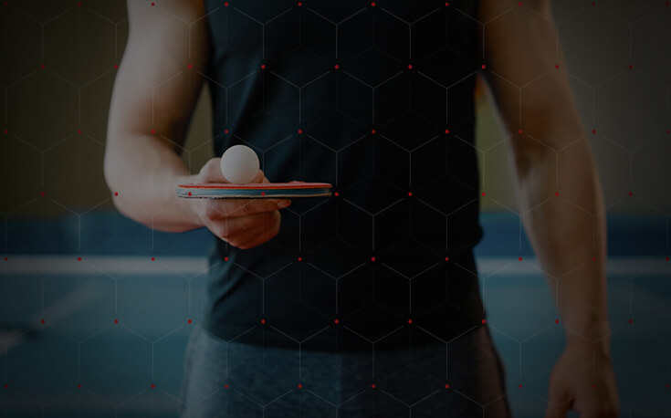 man holding table tennis paddle and ball